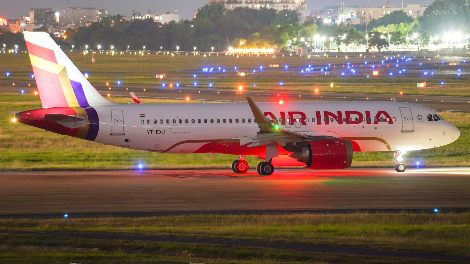 Travellers in the departures hall of an Indian airport at night